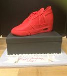 Red sneaker on the black shoe box. 